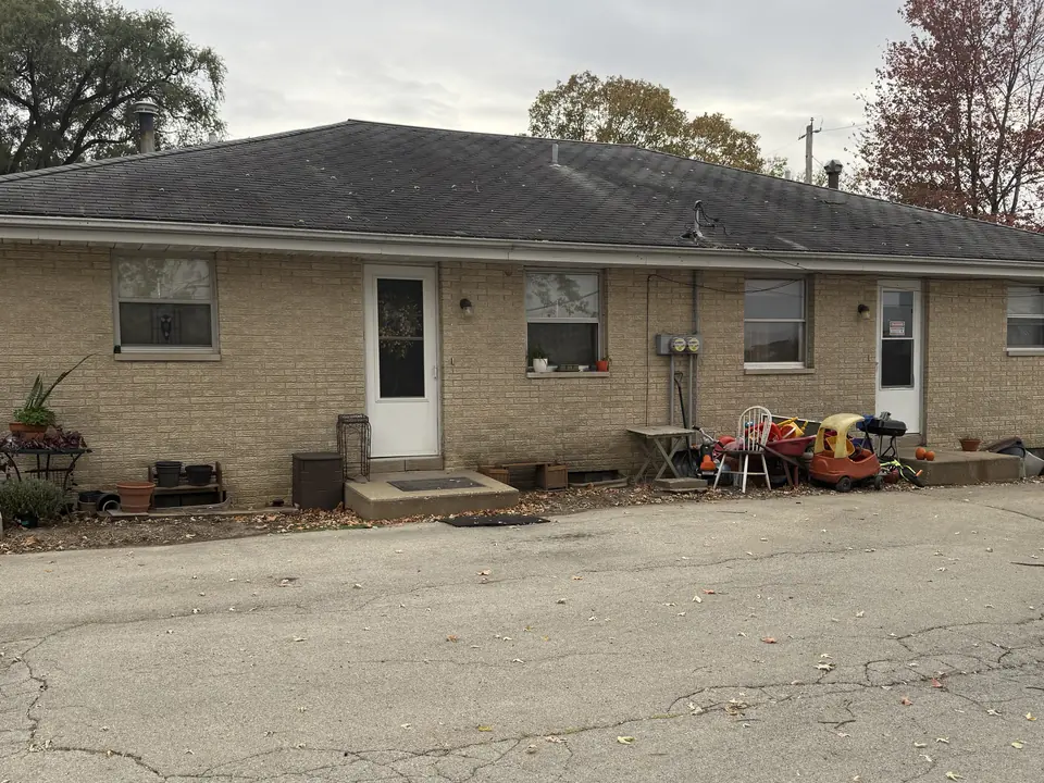Before: Tan brick duplex painted white